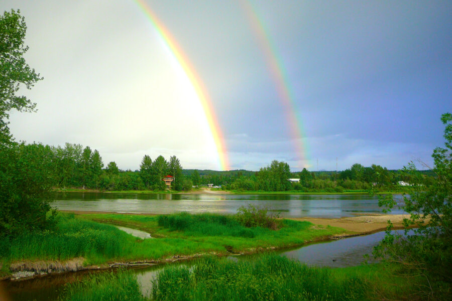 A picture of the Nechako River as seen from the north, with a double rainbow formed in the sky.